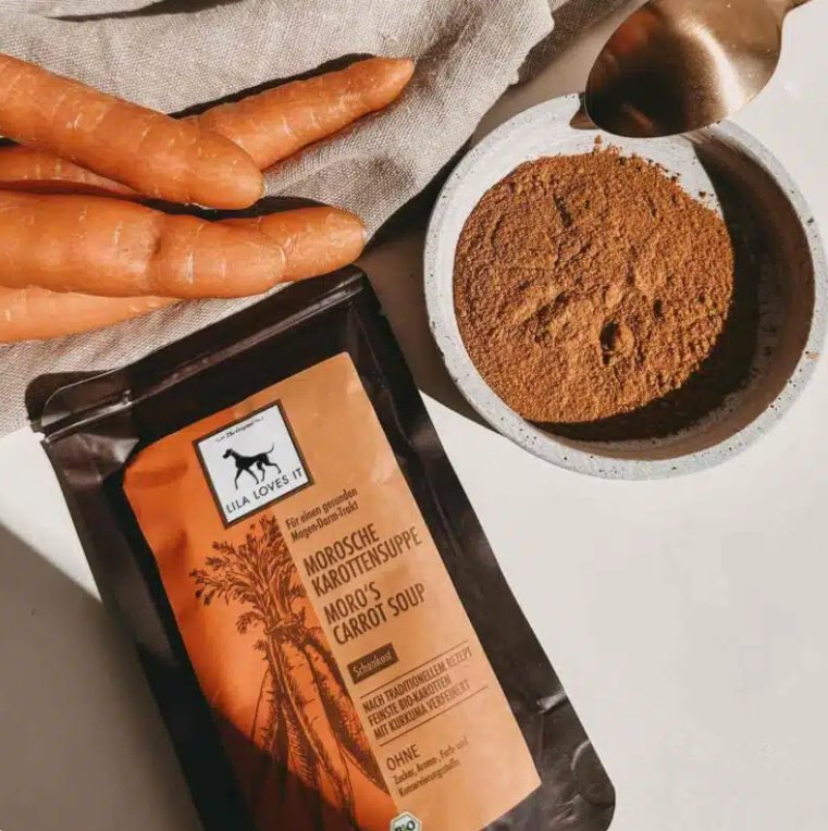 Organic Moro carrot soup package with fresh carrots and spice powder on a countertop.