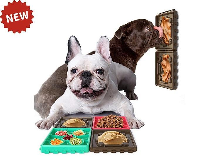 Две кучета се наслаждават на подложка за бавно хранене с храна и лакомства.